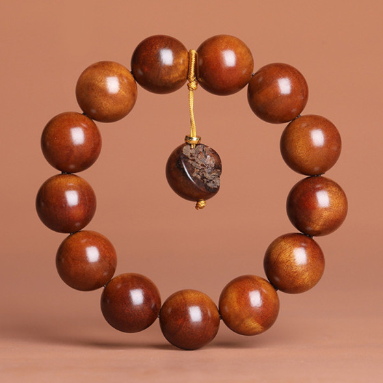 A natural and carefully selected jujube wood cultural and artistic bracelet without lightning spots. A vajra pendant for playing with Chinese Buddhist prayer beads, held by a man
